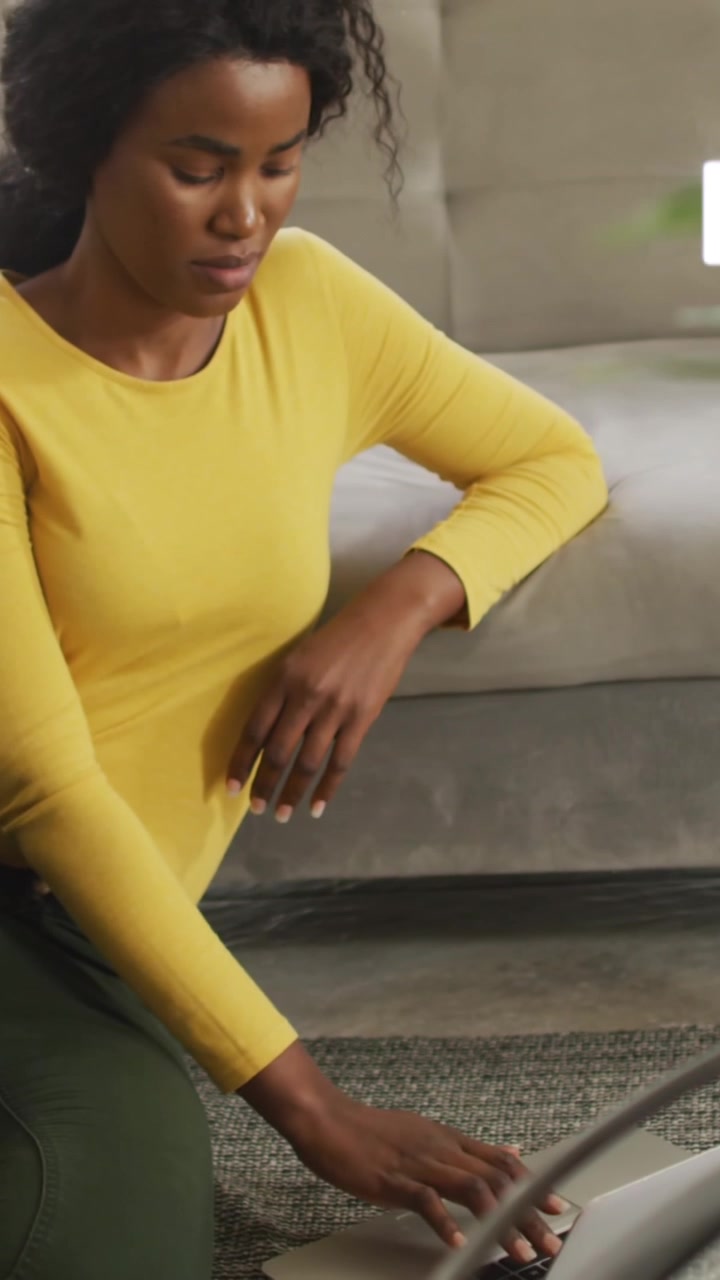 Animation of notification bars, african american woman sitting on floor and scrolling on smartphone