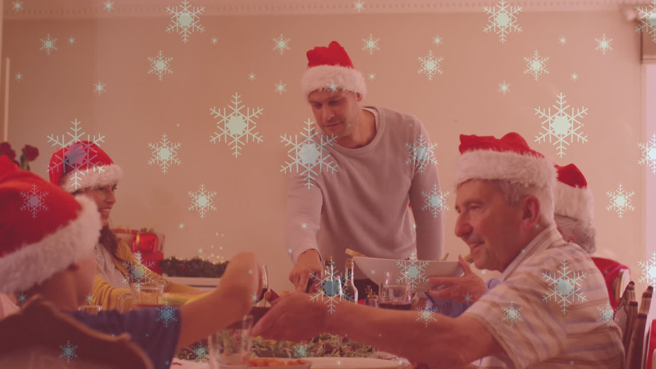 저녁 식사를 하는 산타 모자와 함께 미소 짓는 백인 가족 위에 내리는 눈의 애니메이션