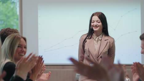 young-woman-financial-expert-is-speaking-in-business-meeting-colleagues-are-supporting-applauding