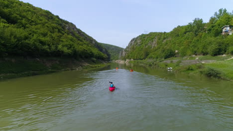 kayak aerial action shot as group paddles towards canyon in kosovo along the drin river