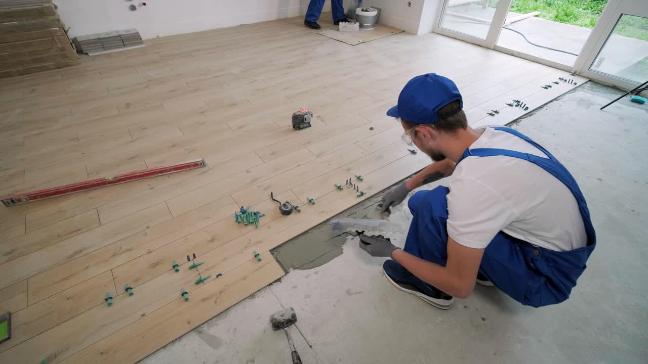 Construction, renovation, repair apartment. Installing ceramic floor tiles - measuring and cutting the pieces. Cuts tile. Tile cutting