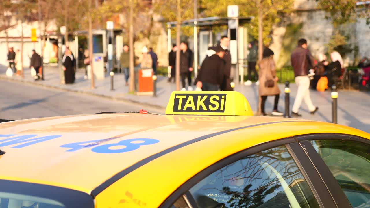 taxi amarillo en una calle de la ciudad con gente