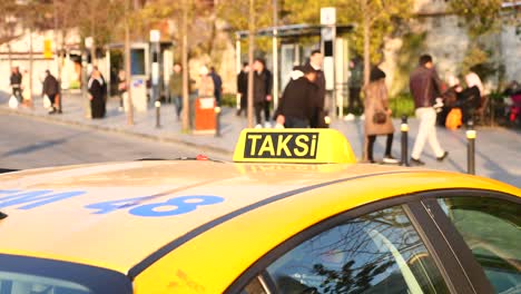 yellow taxi in a city street with people