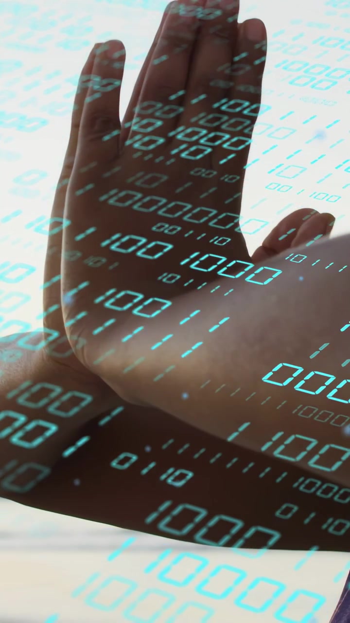 Vertical video: Camera pulling back woman raising then pressing palms centering binary tech beaming