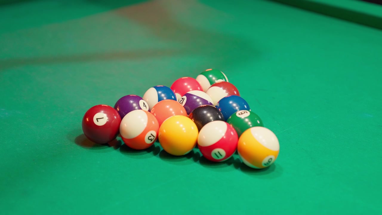 Hands Racking Billiard Balls on a Green Pool Table
