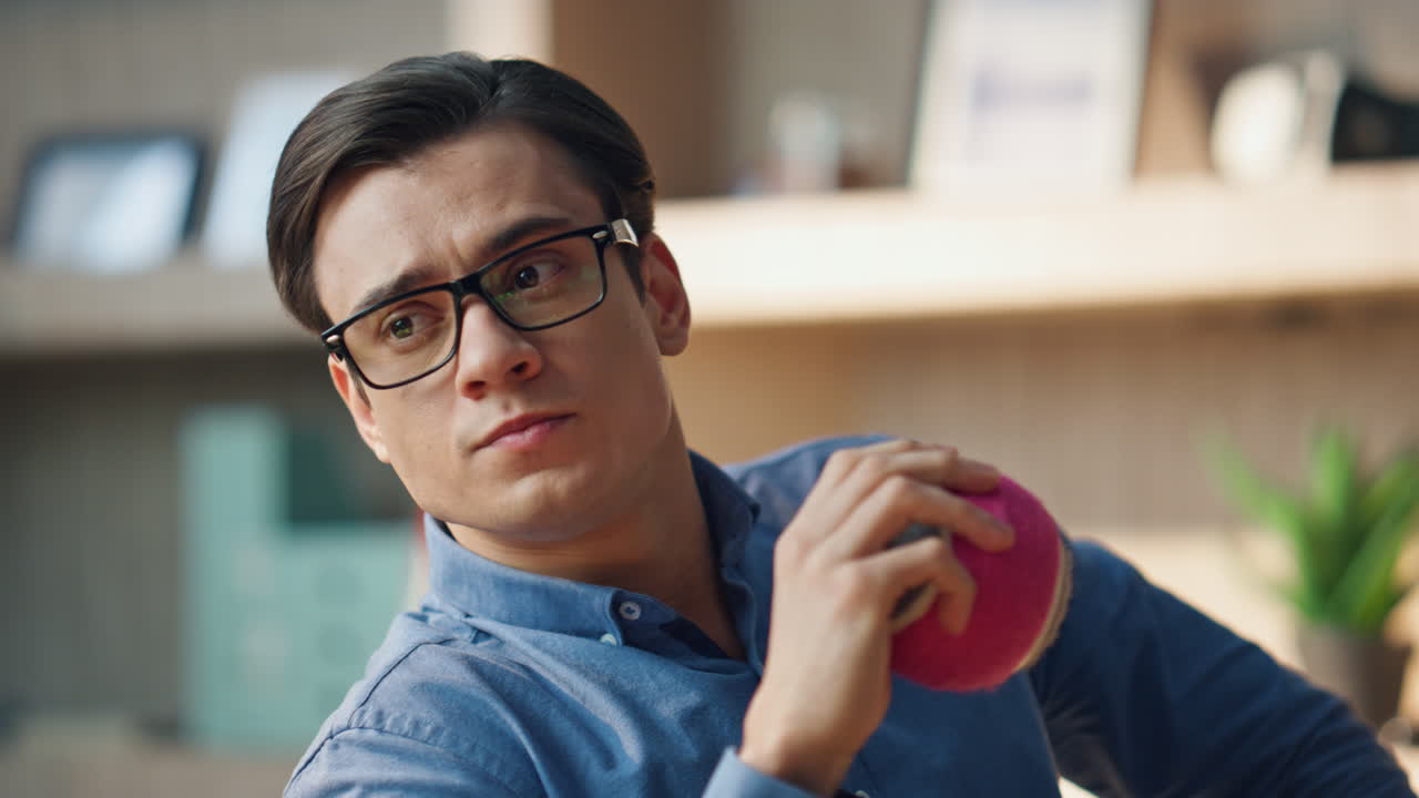 휴식을 취하고 있는 남자가 사무실에서 공을 치고 있다. 디자이너가 휴식을 취하면서 장난감을 던지고 있다.