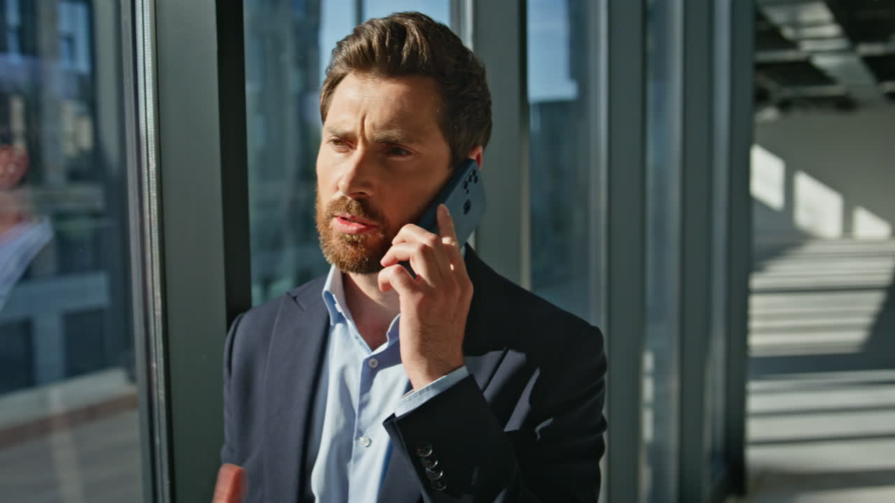 Bearded ceo speaking cellphone modern architecture building closeup. Man calling