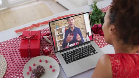 Pareja-Diversa-En-Una-Videollamada-De-Una-Cita-De-San-Valentín-Al-Hombre-En-La-Pantalla-Mostrando-El-Anillo-A-La-Mujer