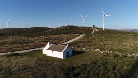 Iglesia-En-Las-Montañas-Con-Vista-Aérea-De-Turbinas-Eólicas.