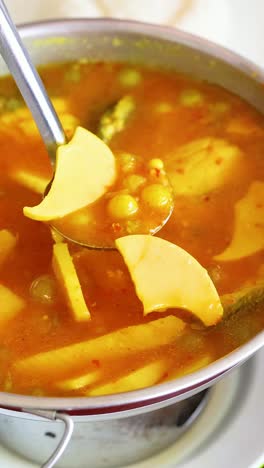 ladling curry into a bowl at a restaurant