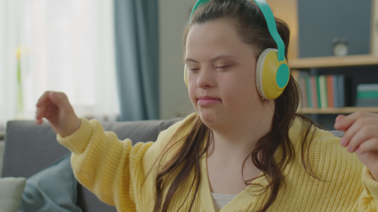 Girl with Down Syndrome Enjoying Music with Wireless Headphones