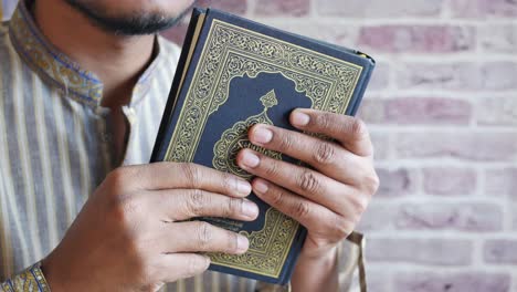 muslim man hand holding holy book quran with copy space ,