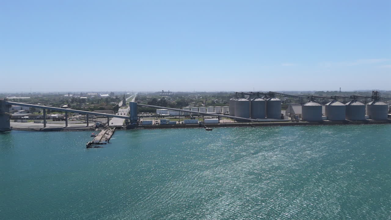Sideways drone movement about the industrial port near the waterfront, Necochea, Argentina.