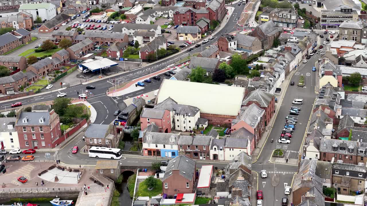 Drone aerial view pans over Dundee’s residential buildings, urban streets, and town centre in daylight