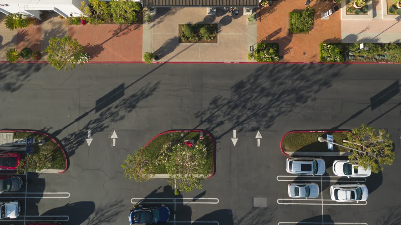 top down aerial time lapse captures customers parking and shopping at department stores on a beautiful day