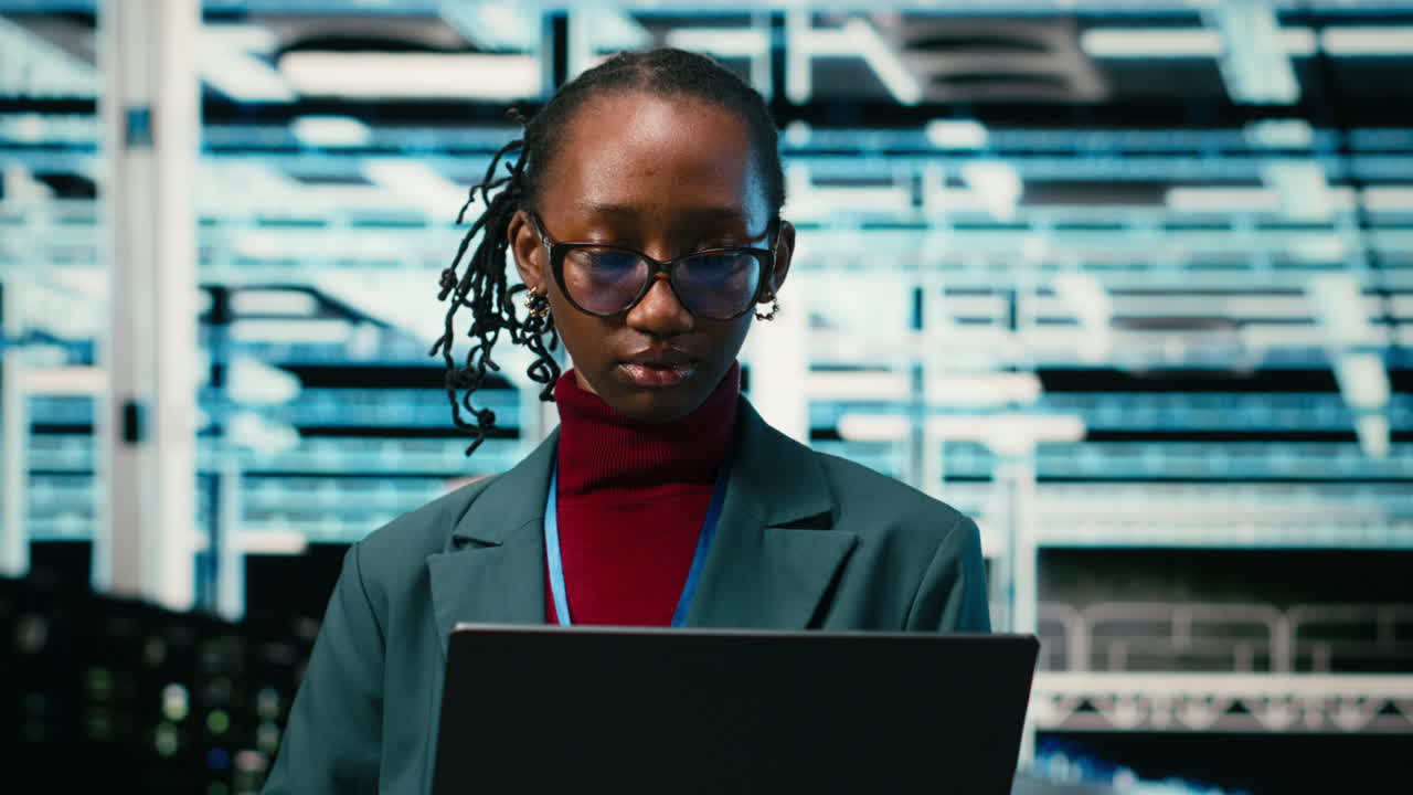 Smiling African American Woman Working on Laptop in Data Center