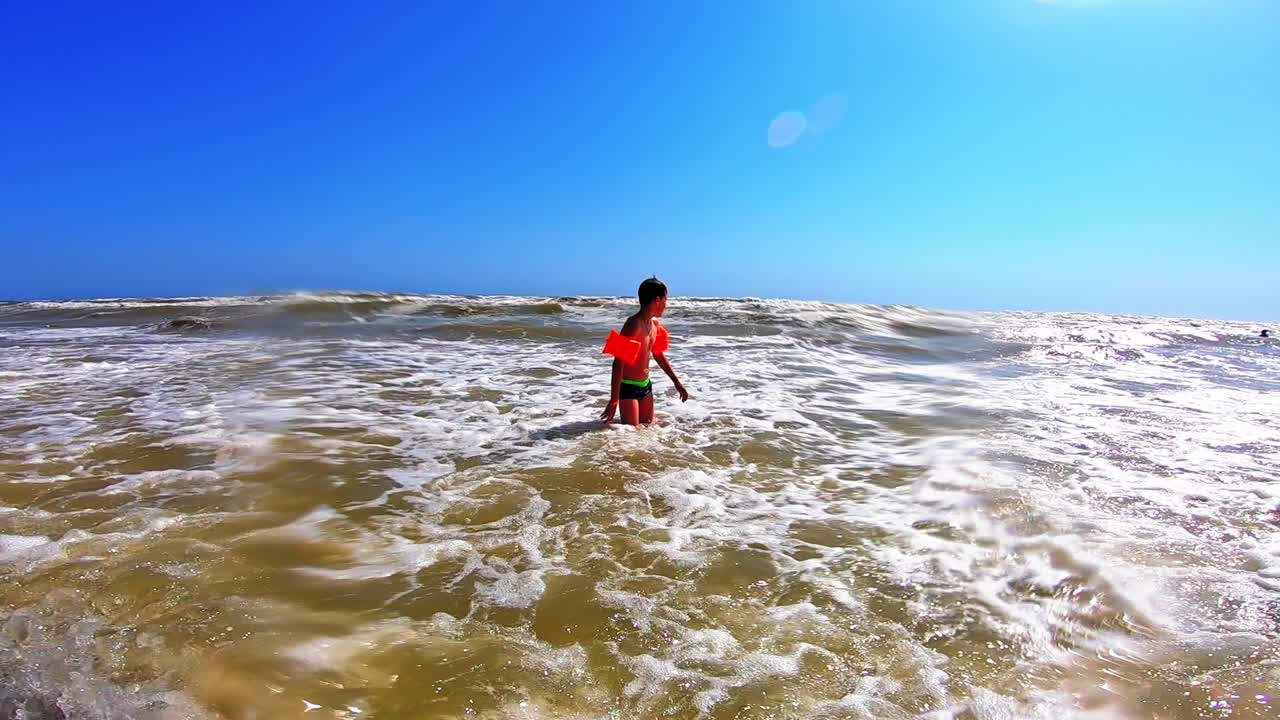 Boy playing on beach. Happy boy playingin sea water