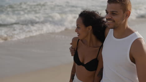 una pareja linda caminando por la playa.