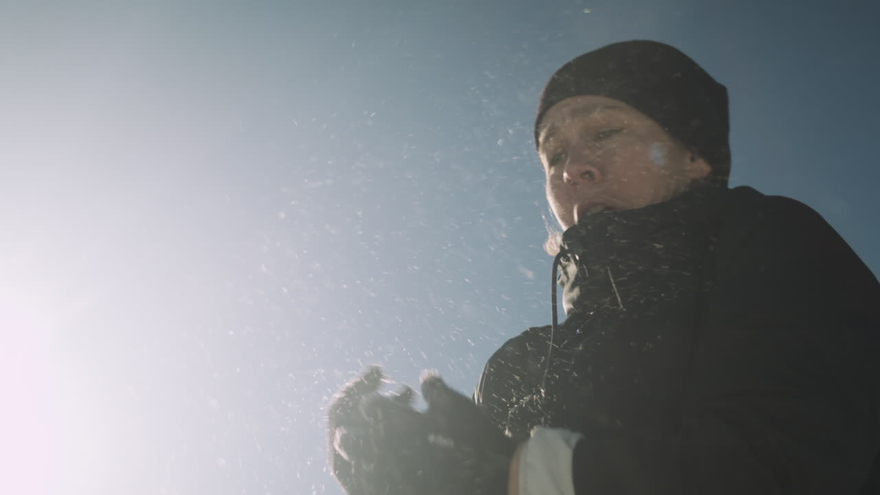 удивленная женщина, в которую попали снежком, пытается защититься руками, замедленная съемка крупным планом