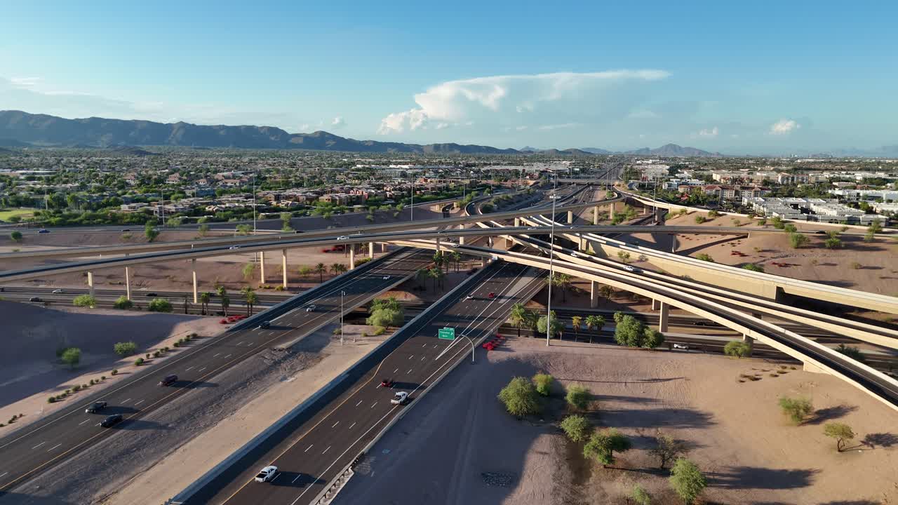 Aerial View of Highway interchange in Chandler Arizona, Interstate 10, Arizona State Route 202, South Mountain, early evening, blue sky with couple clouds, cars driving on road