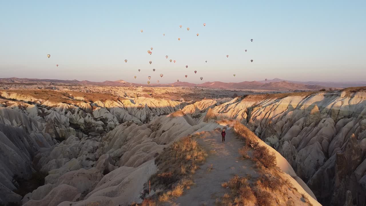 caminando en capadocia al amanecer con globos de colores en el cielo