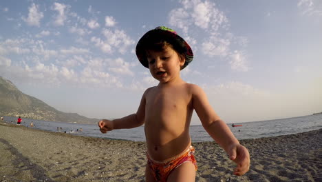 wide footage of a boy playing ay the beach kalamata,greece