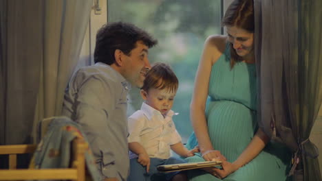 Parents-and-child-playing-on-touch-pad-at-home