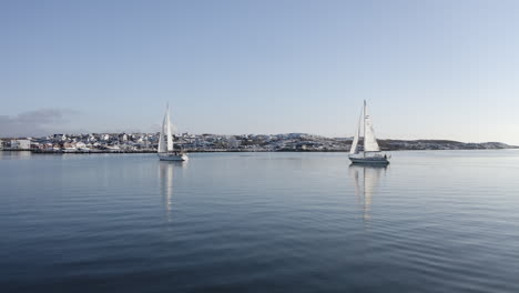 Toma-Aérea-De-Dos-Hermosos-Barcos-De-Vela-En-Un-Soleado-Día-De-Invierno-En-El-Municipio-De-La-Isla-De-Öckerö-En-El-Archipiélago-De-Gotemburgo,-Suecia