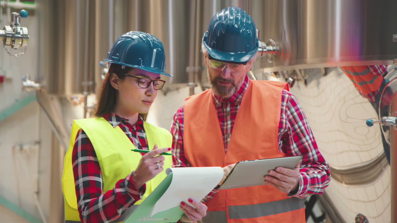 Industrial workers discussing plans in a manufacturing plant
