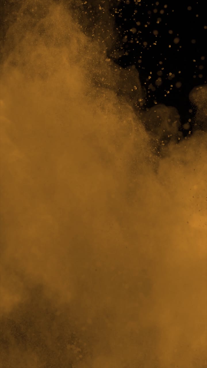Orange Powder Exploding on Black Background Vertical Video 4k