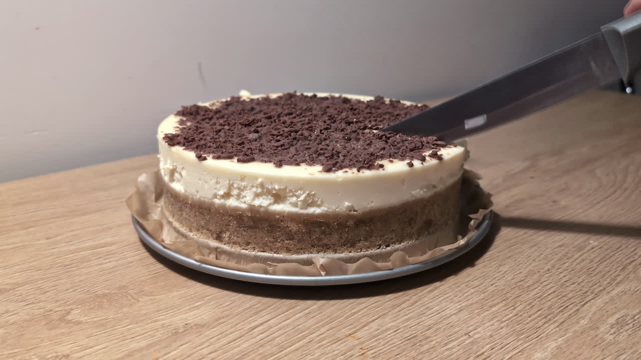 Usare un coltello affilato per tagliare una deliziosa torta, vista statica