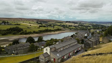 pro aerial video of a industrial rural village with old mill and chimney stack surrounded by fields