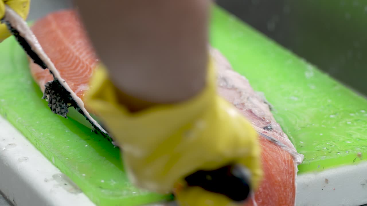Witness the intricate process of salmon filleting as a skilled chef works meticulously in a vibrant kitchen close to sunset. The colors and details come alive in this culinary journey