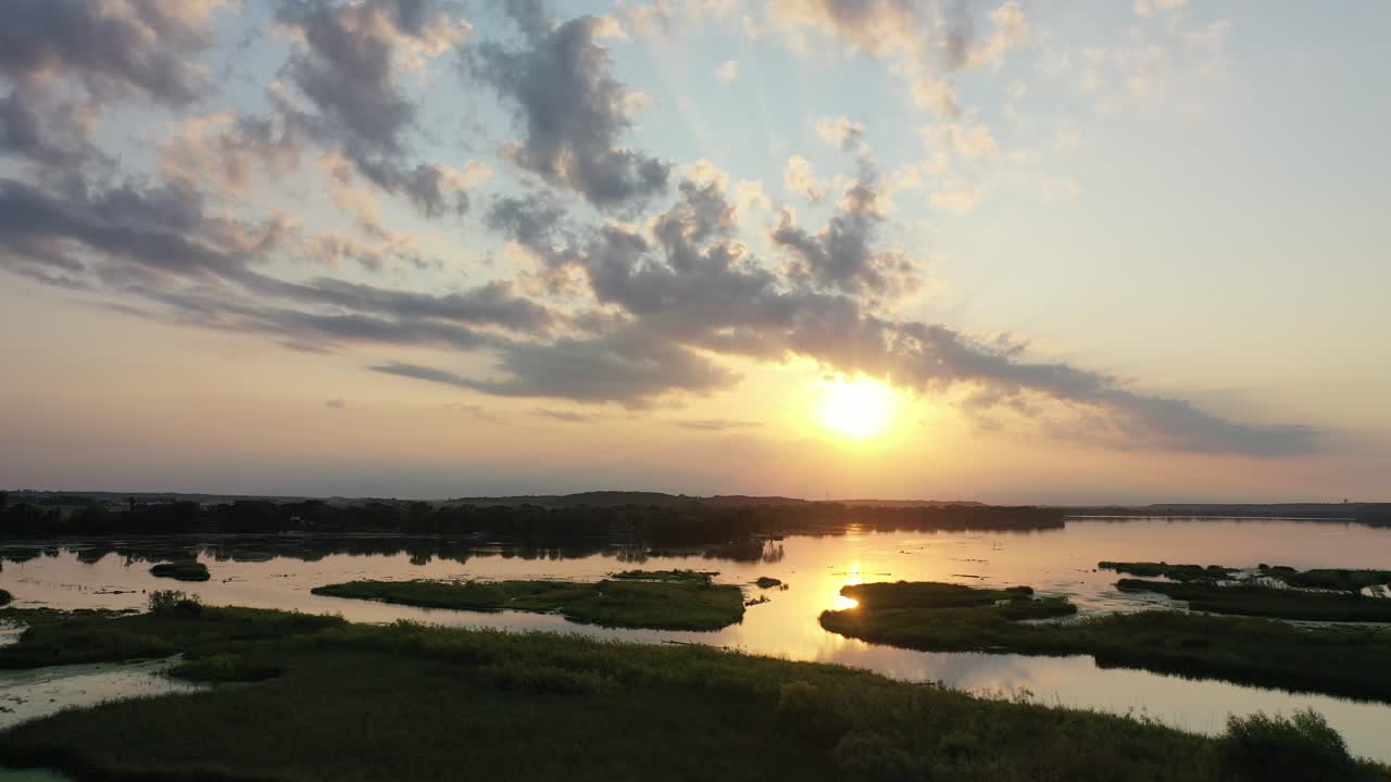o pôr-do-sol sobre um pântano e um rio