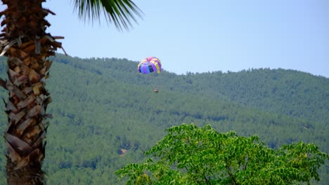 tourists parasailing fly to the ocean shore, tourist season and travel concept. antalya, turkey. flying with parachute