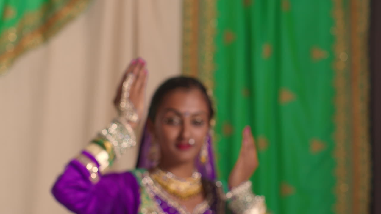 fotografía de estudio de una mujer sonriente bailando kathak con un vestido tradicional indio