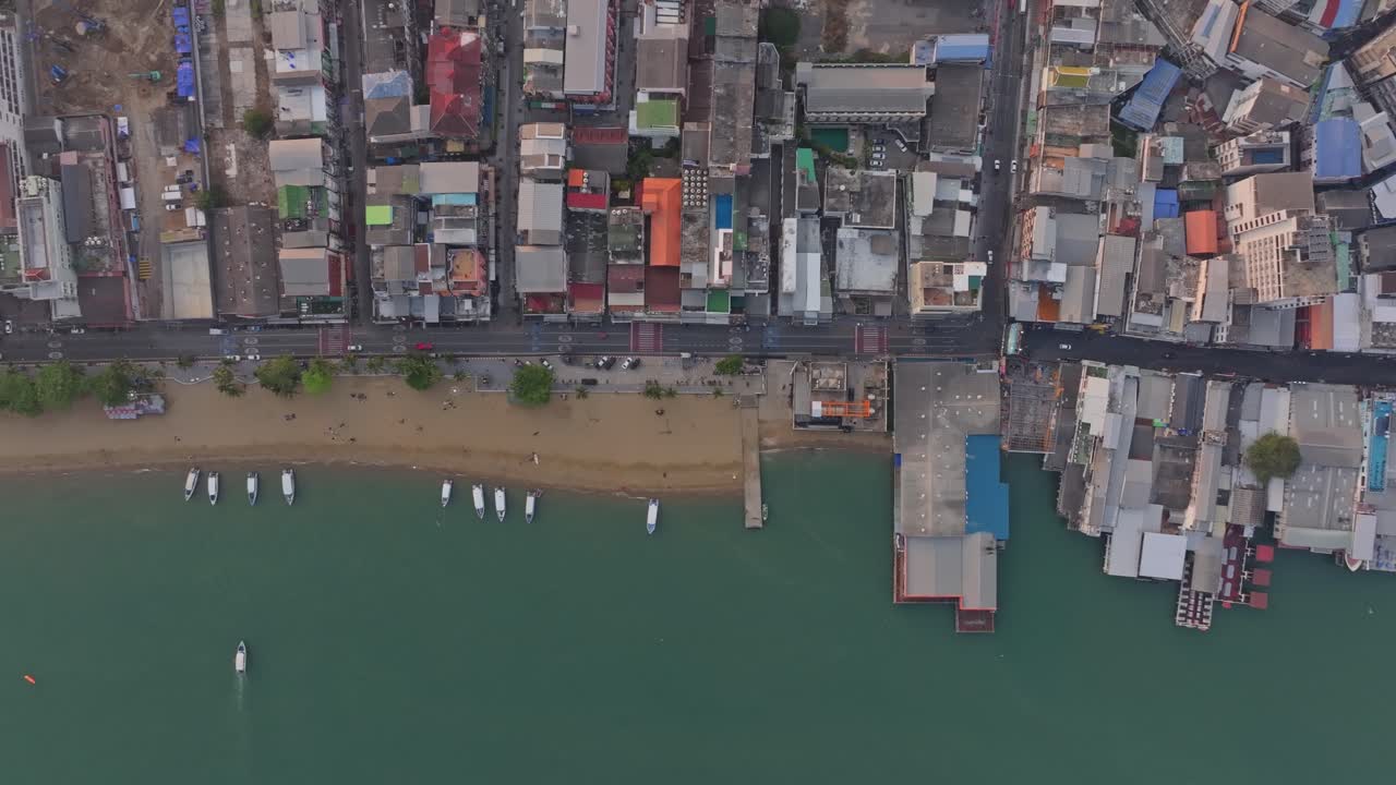 Hotel e spiaggia fiancheggiata da palme riflettono l'alba a Pattaya, Thailandia