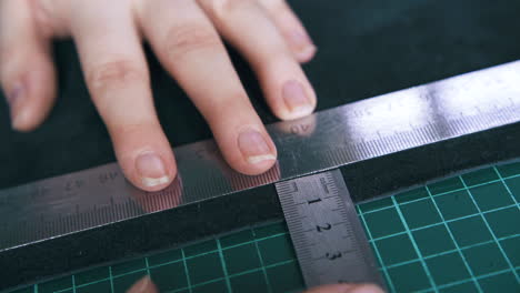 professional tailor measures leather with rulers closeup