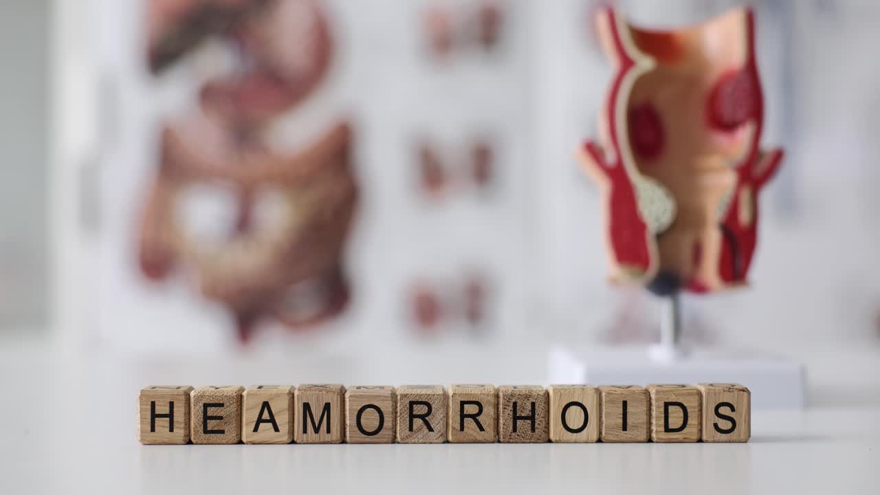 Wooden Blocks Spelling Hemorrhoids with Anatomical Models in Background