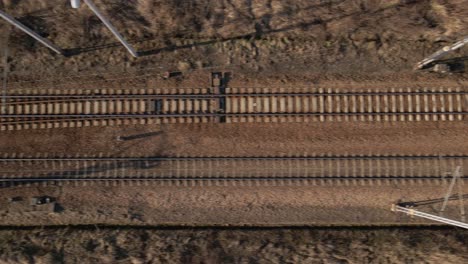 Vista-De-Pájaro-Del-Ferrocarril-Durante-La-Puesta-De-Sol-Y-La-Hora-Dorada,-Moviéndose-Hacia-Los-Lados---Imágenes-De-Drones