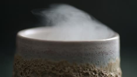 close-up macro of a lot of flowing smoke over a ceramic glass