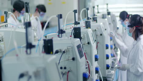 scientific laboratory researcher in lab coats wearing safety glasses goggles conducting biological experiment with automated machinery. ideal for themes research, technology, medical advancements