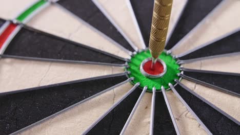 closeup of dartboard with darts hitting bullseye