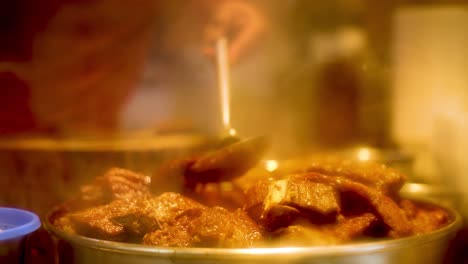 chef preparing stewed beef with ladle in kitchen