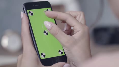 mujer usando un teléfono inteligente con una pantalla verde
