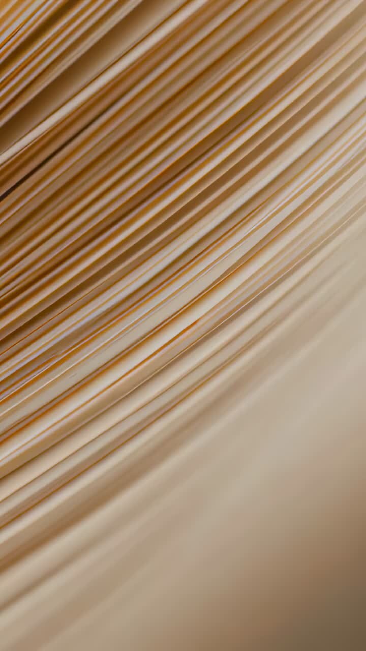 Video verticale: messa a fuoco con obiettivo che rende più chiare le linee delle lenzuola color crema sul tavolo da studio, luce calda