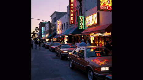 night scene on a city street with neon signs and cars