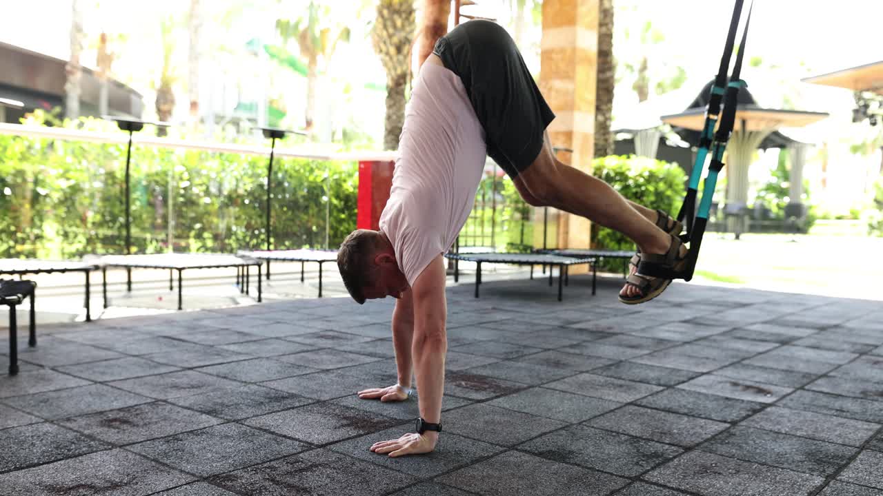 Professional athlete does push ups with legs attached