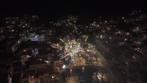 beautiful footage of night fireworks over symi harbor in greece with light reflections on calm aegean waters. filmed on easter 2025-04-20.