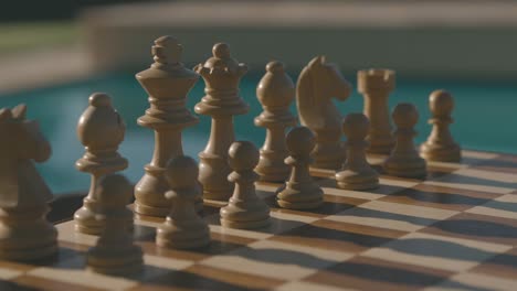 Detail-of-a-chess-board-placed-in-the-sun-in-the-late-afternoon,-you-can-see-the-shadows-of-the-pieces-cast-on-the-board